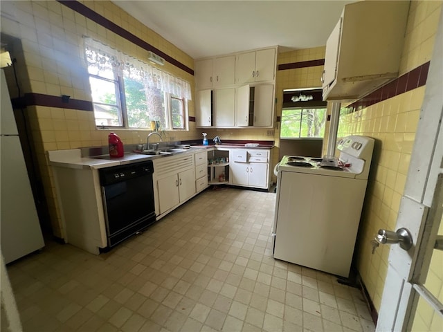 kitchen featuring black dishwasher, sink, tile walls, white cabinets, and white stove