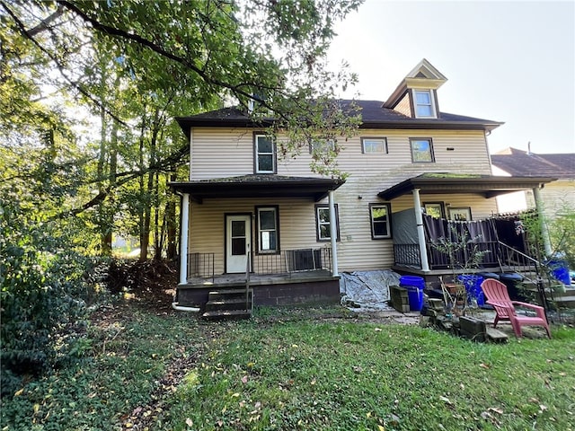 back of property with a porch and a lawn