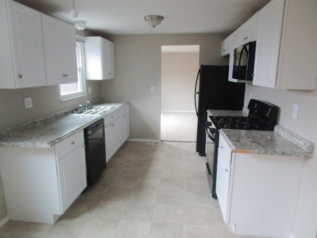 kitchen featuring black appliances, white cabinetry, and sink