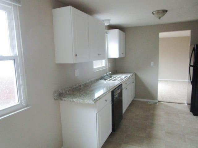 kitchen with black appliances, a healthy amount of sunlight, and white cabinets