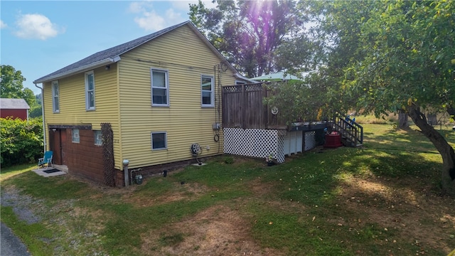 view of property exterior featuring a yard and a wooden deck