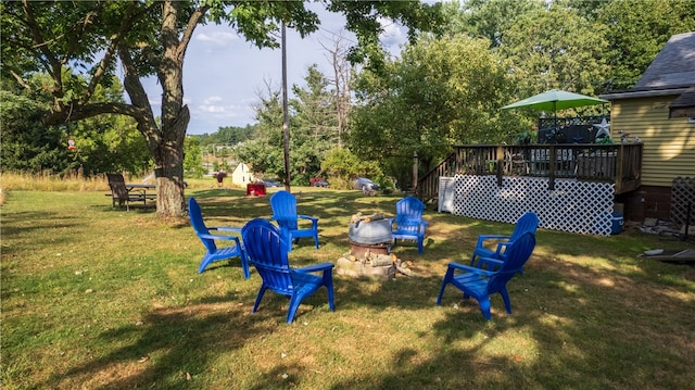 view of yard with a wooden deck and an outdoor fire pit