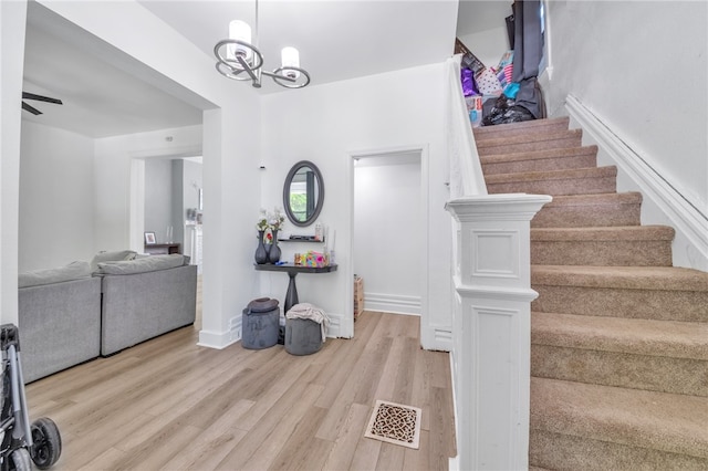 entryway featuring light hardwood / wood-style flooring and ceiling fan with notable chandelier