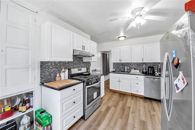 kitchen featuring appliances with stainless steel finishes, tasteful backsplash, ceiling fan, light hardwood / wood-style flooring, and white cabinets