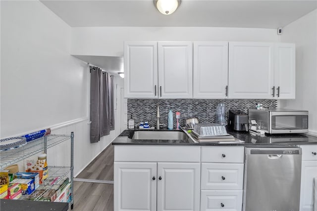 kitchen with sink, stainless steel appliances, backsplash, and white cabinets