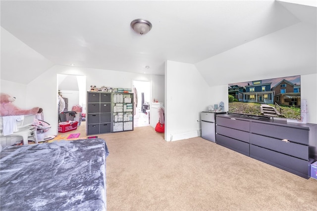 bedroom featuring a closet, light carpet, a spacious closet, and vaulted ceiling