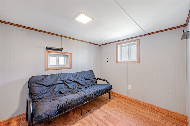 living area with ornamental molding and light hardwood / wood-style flooring