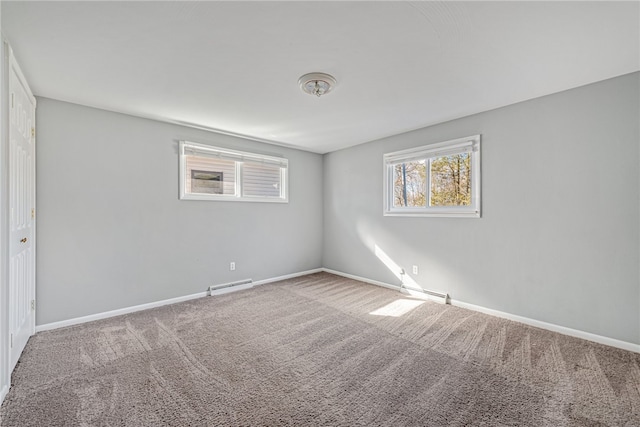 carpeted spare room featuring a baseboard heating unit