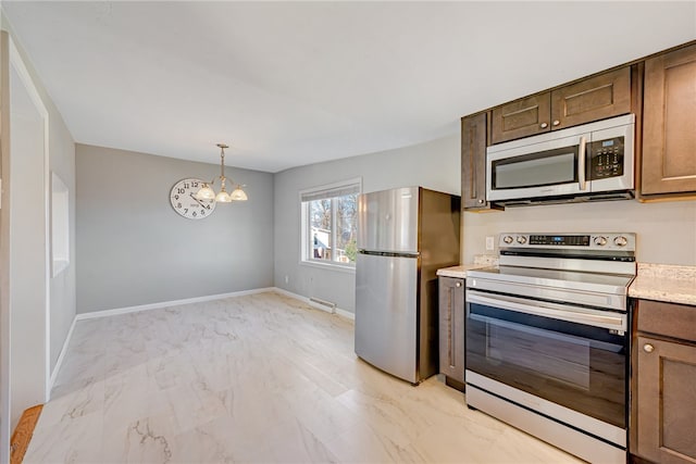 kitchen with pendant lighting, stainless steel appliances, a baseboard heating unit, and an inviting chandelier