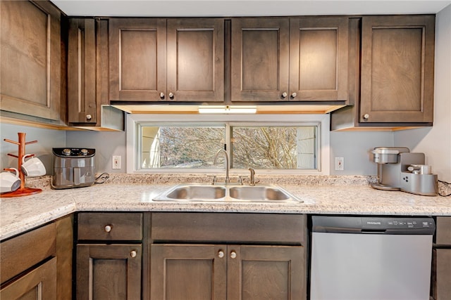 kitchen with light stone counters, stainless steel dishwasher, dark brown cabinetry, and sink