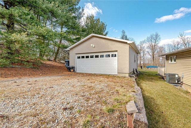 garage featuring central air condition unit and a yard