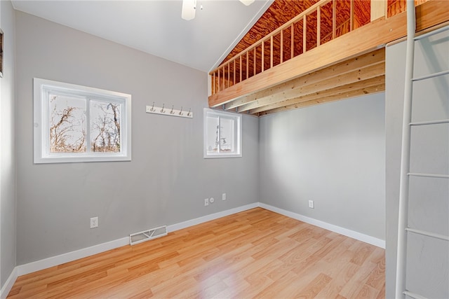 empty room featuring vaulted ceiling and light hardwood / wood-style floors