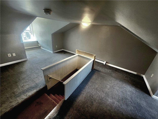 interior space featuring lofted ceiling, a baseboard radiator, and dark carpet