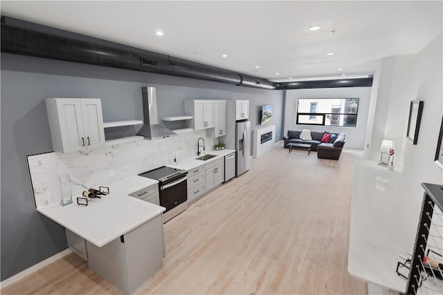 kitchen featuring light hardwood / wood-style floors, stainless steel appliances, tasteful backsplash, white cabinetry, and sink