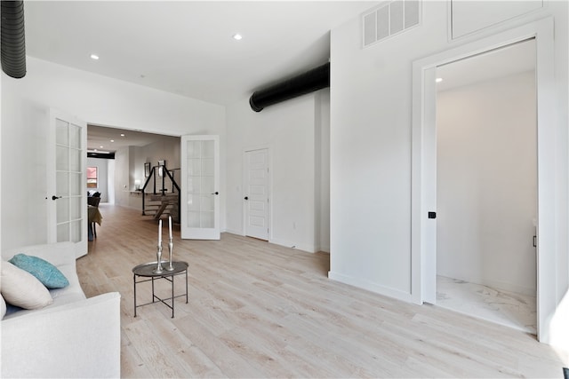 living area with french doors and light wood-type flooring