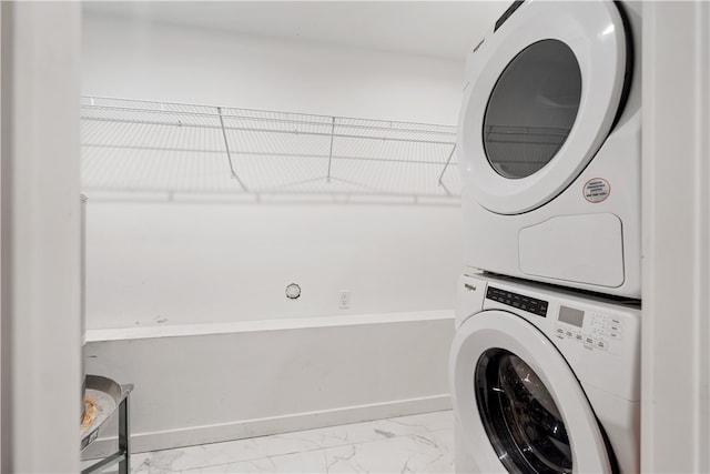 clothes washing area with light tile floors and stacked washer and clothes dryer