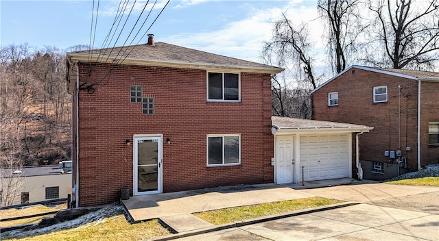 back of property featuring central air condition unit and a garage