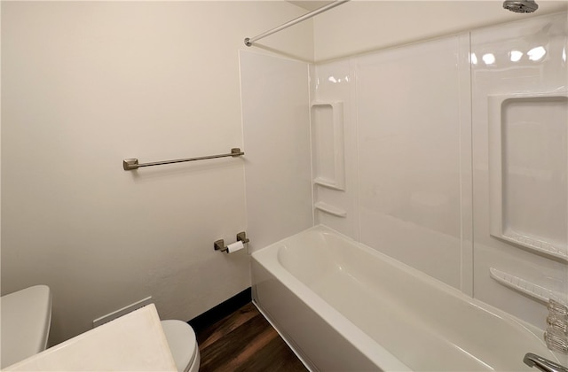 bathroom with toilet, washtub / shower combination, and hardwood / wood-style flooring