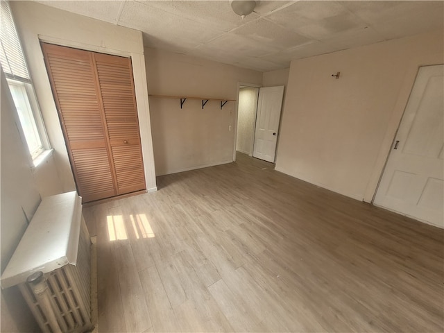 unfurnished bedroom featuring a closet and light wood-type flooring