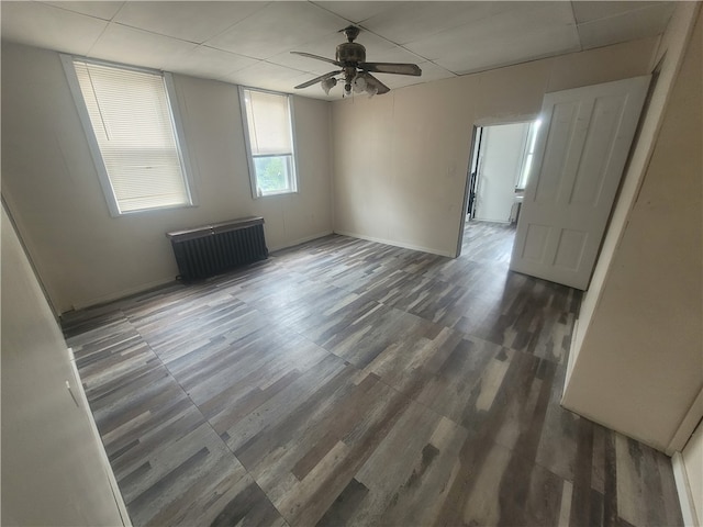 spare room featuring a paneled ceiling, ceiling fan, and dark hardwood / wood-style flooring