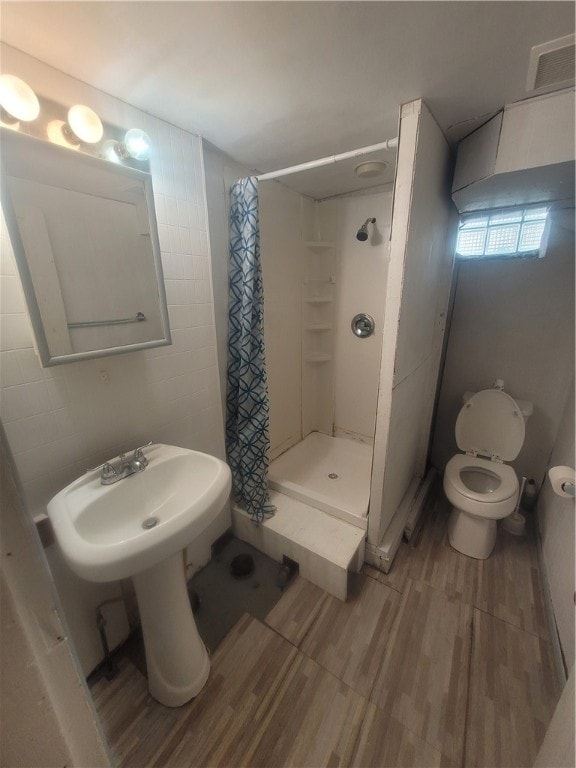 bathroom featuring curtained shower, toilet, and hardwood / wood-style floors