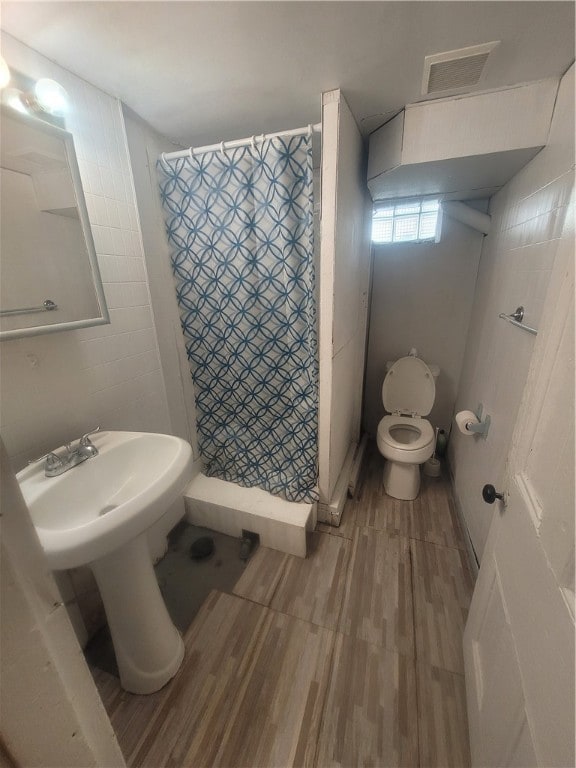 bathroom with toilet and hardwood / wood-style flooring