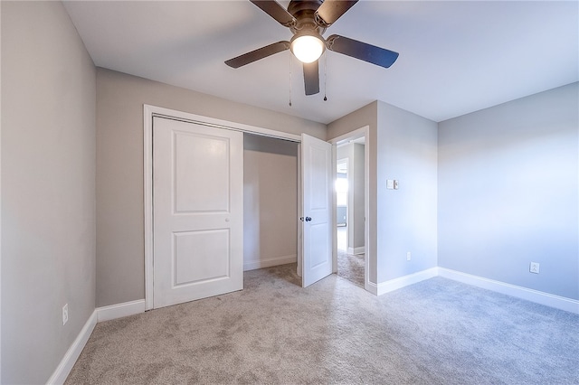 unfurnished bedroom featuring light colored carpet, a closet, and ceiling fan