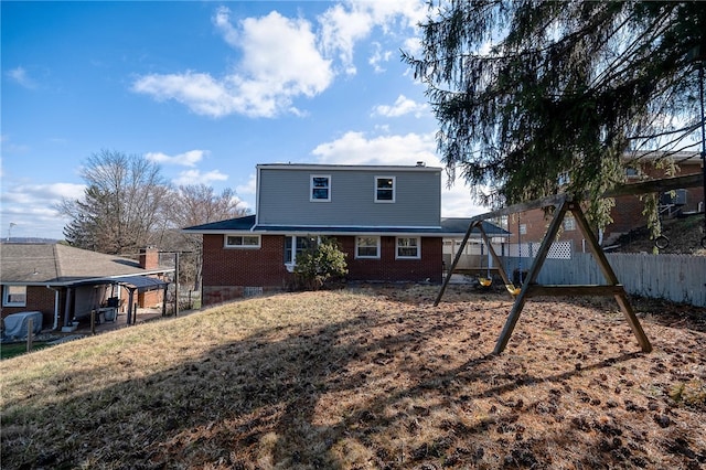 rear view of property with a playground