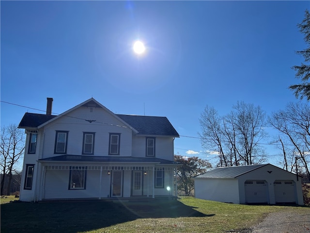 view of front of home with covered porch, a front lawn, an outdoor structure, and a garage