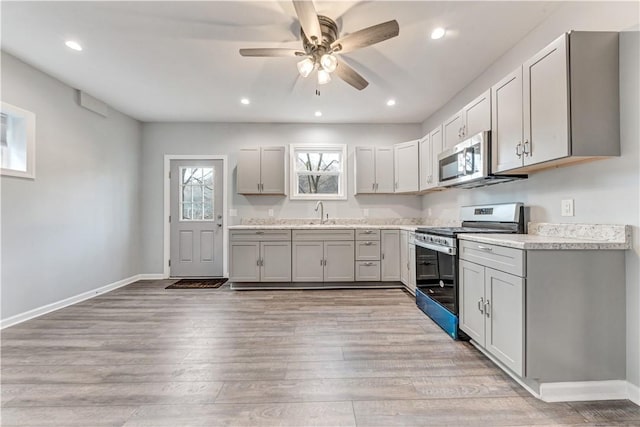 kitchen featuring gray cabinetry, ceiling fan, sink, light hardwood / wood-style flooring, and appliances with stainless steel finishes