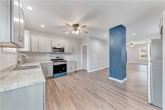 kitchen with ceiling fan, light wood-type flooring, sink, and appliances with stainless steel finishes