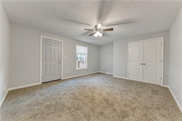 unfurnished bedroom featuring carpet, ceiling fan, and a textured ceiling