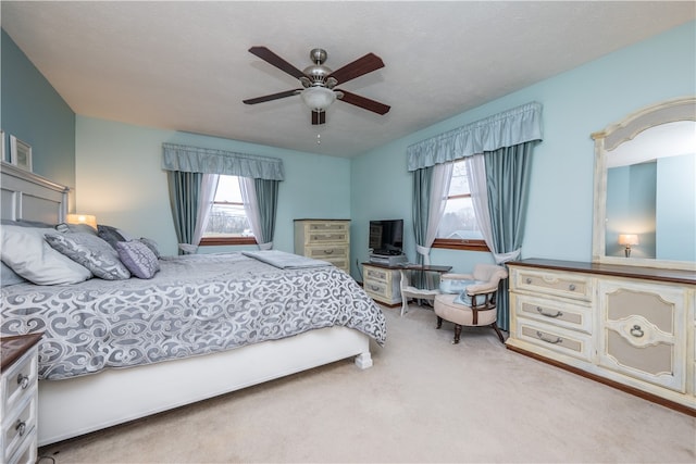 carpeted bedroom with ceiling fan and multiple windows