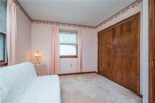 carpeted bedroom featuring a textured ceiling and a closet