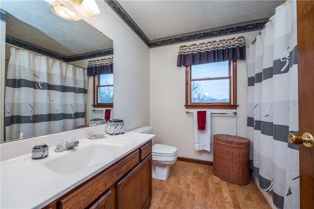 bathroom featuring oversized vanity, toilet, a textured ceiling, and hardwood / wood-style floors