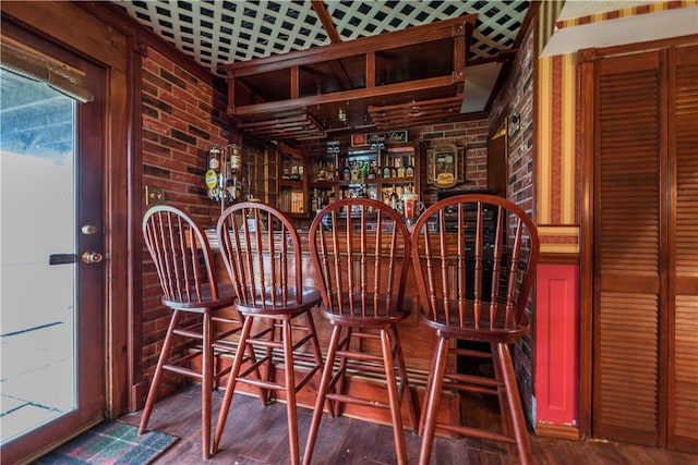 bar featuring brick wall and dark hardwood / wood-style floors