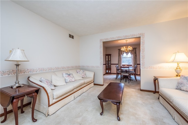 living room with a notable chandelier and light colored carpet