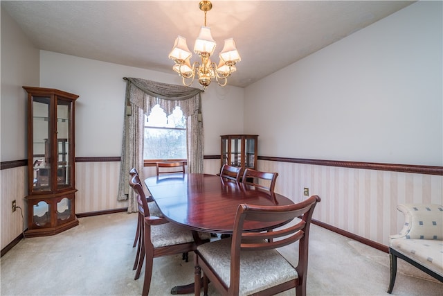 carpeted dining room featuring a notable chandelier