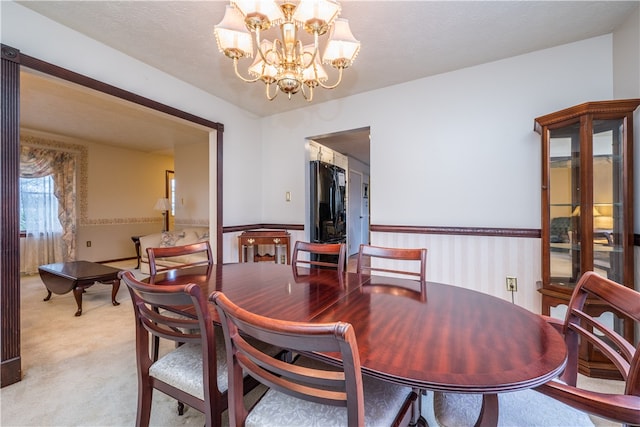 carpeted dining room with an inviting chandelier