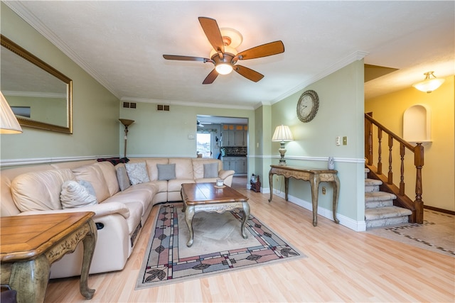 living room featuring light hardwood / wood-style floors, ceiling fan, and ornamental molding