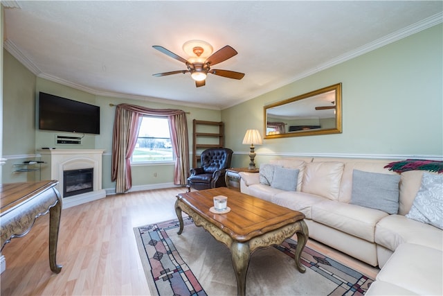 living room featuring ceiling fan, ornamental molding, and light wood-type flooring