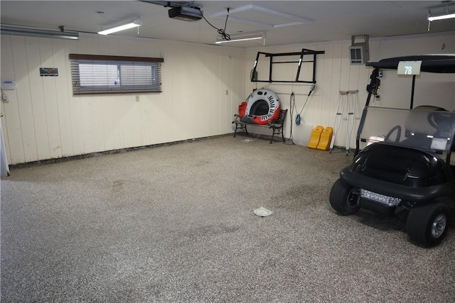 garage featuring a garage door opener and wooden walls