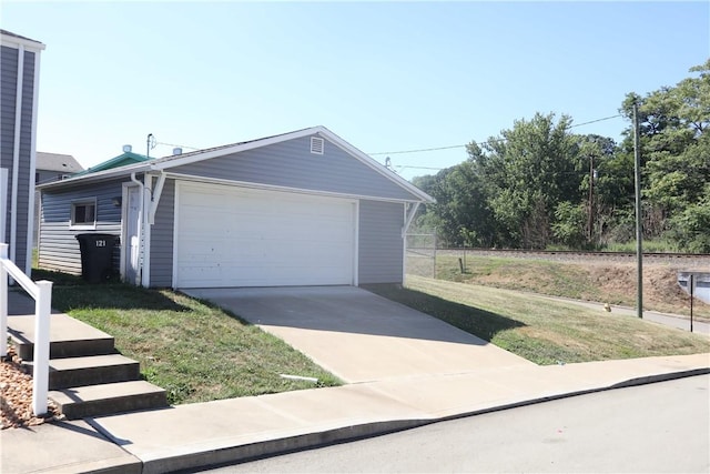 view of front of house with a garage, an outbuilding, and a front lawn