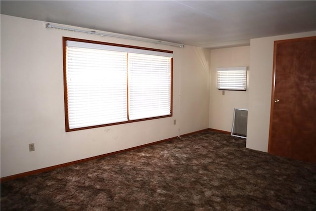 spare room featuring dark colored carpet