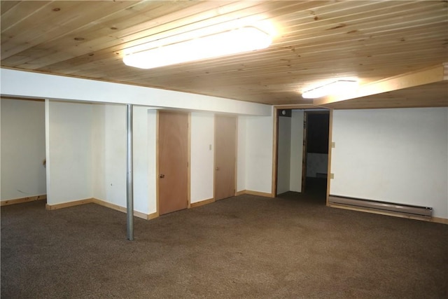 basement with wooden ceiling, a baseboard heating unit, and dark carpet