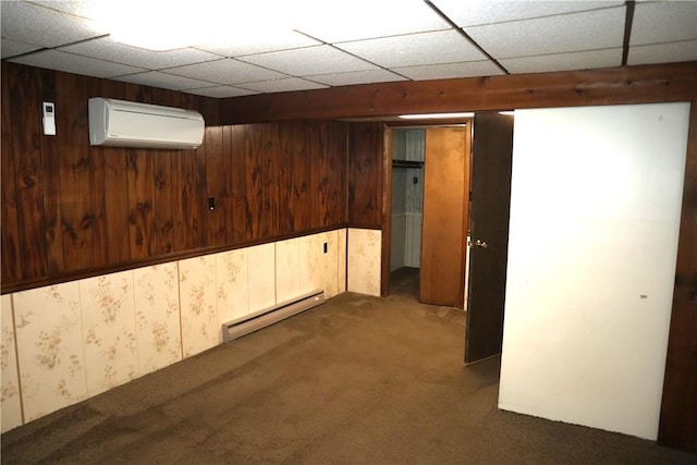 basement with a baseboard heating unit, wood walls, a wall mounted air conditioner, and carpet floors