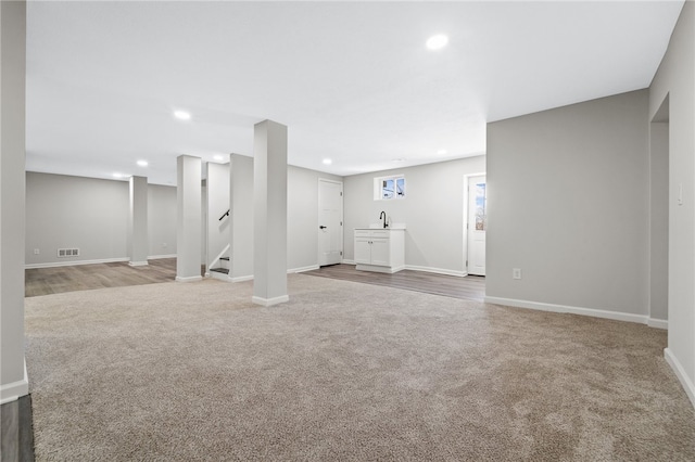 basement with sink and hardwood / wood-style floors