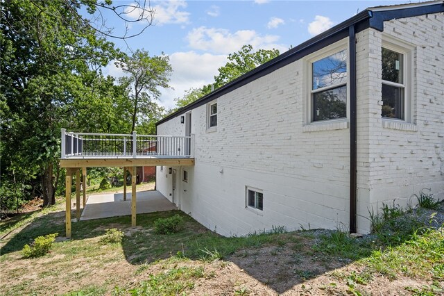 view of side of home featuring a patio and a wooden deck