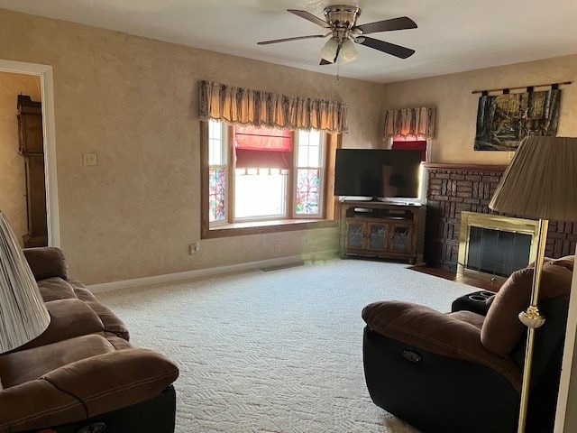 carpeted living room with ceiling fan and a fireplace