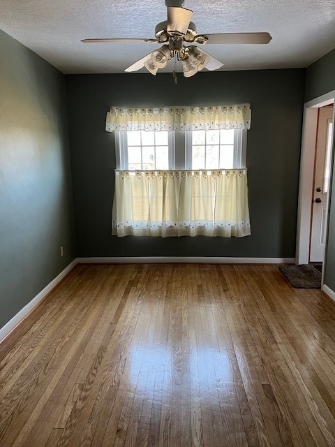 unfurnished room with a textured ceiling, ceiling fan, and wood-type flooring